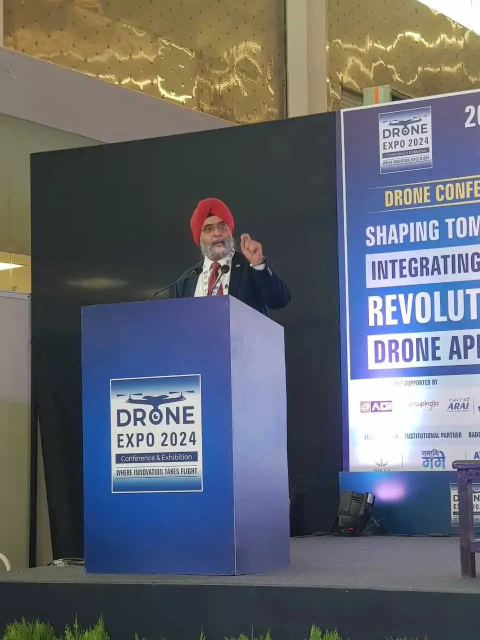 Speaker at the podium addressing the audience at Drone Expo 2024 conference and exhibition