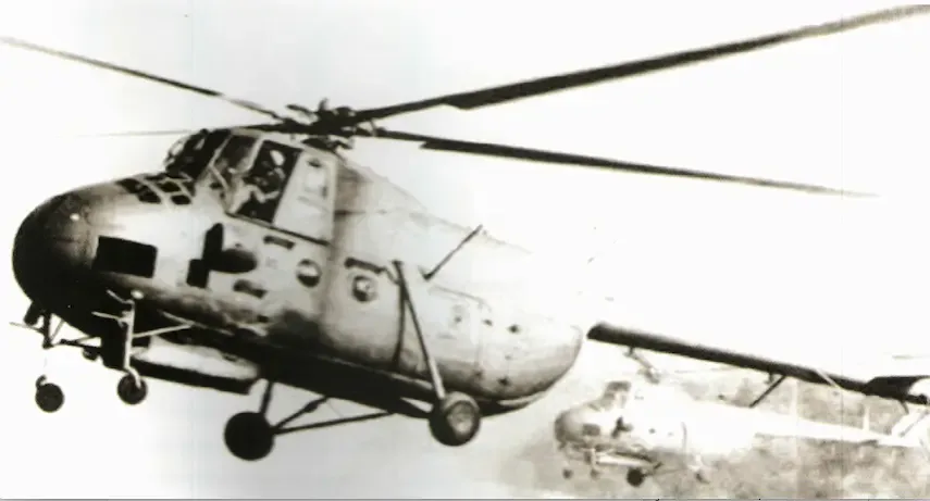 Vintage black-and-white photograph of an Mi-4 helicopter in flight with a second helicopter visible in the background