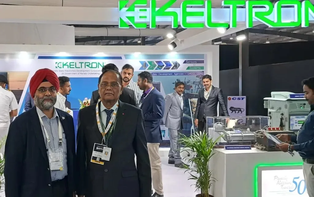 Officials standing at the Keltron exhibition booth showcasing defence sensor and systems technology